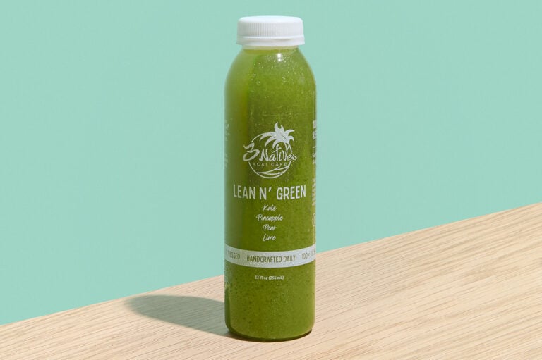 Lean N' Green cold-pressed juice with pineapple, pear, kale, and lime in a clear bottle.